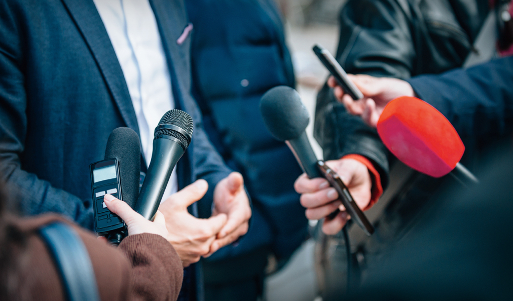 Business people being interviewed with microphones