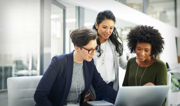 Group of people working together around a laptop